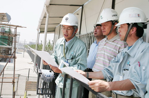 スタッフが、崔天凱氏一行に建設中の日本館工事を紹介